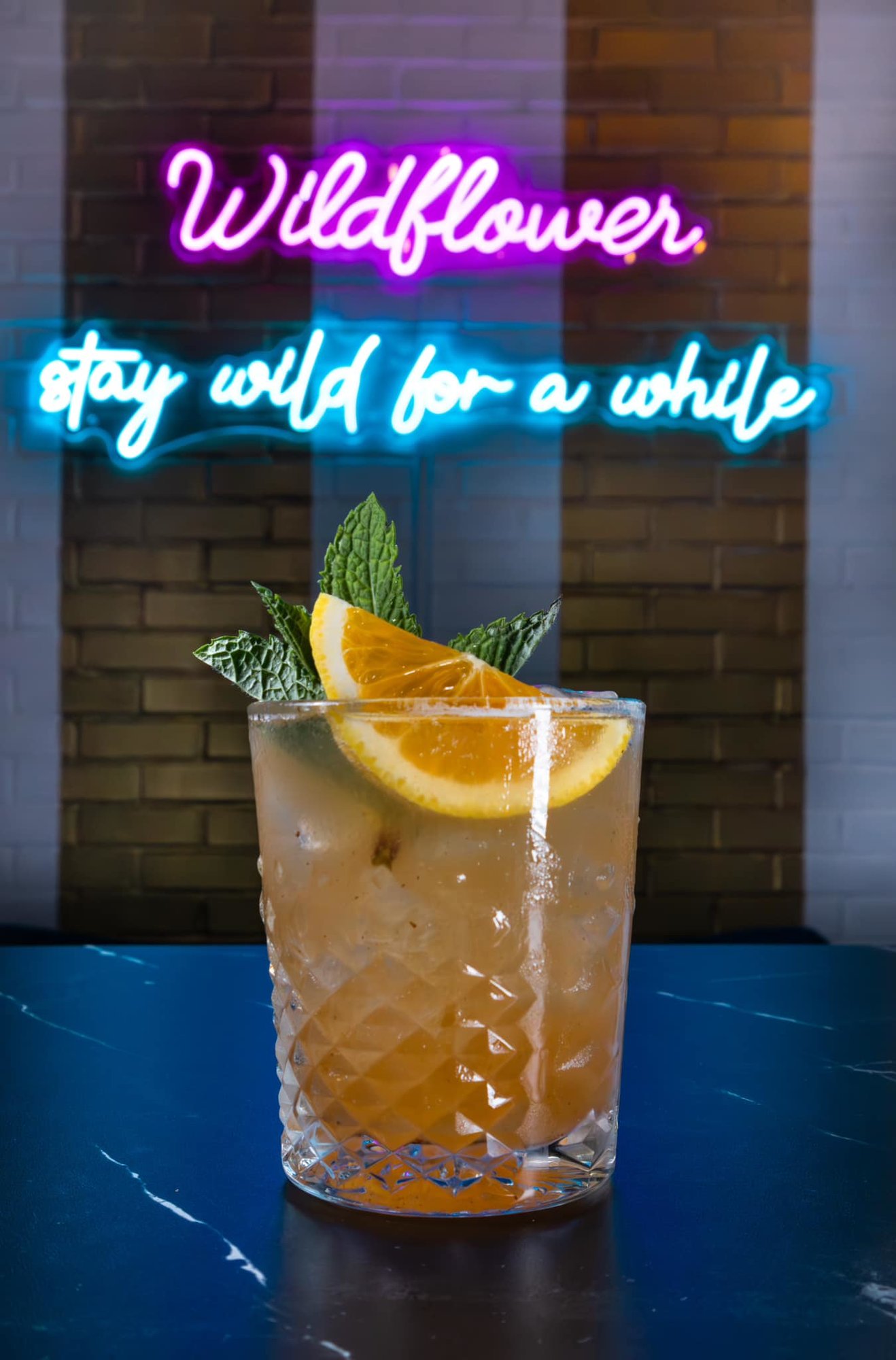mixed drink with lit up sign behind